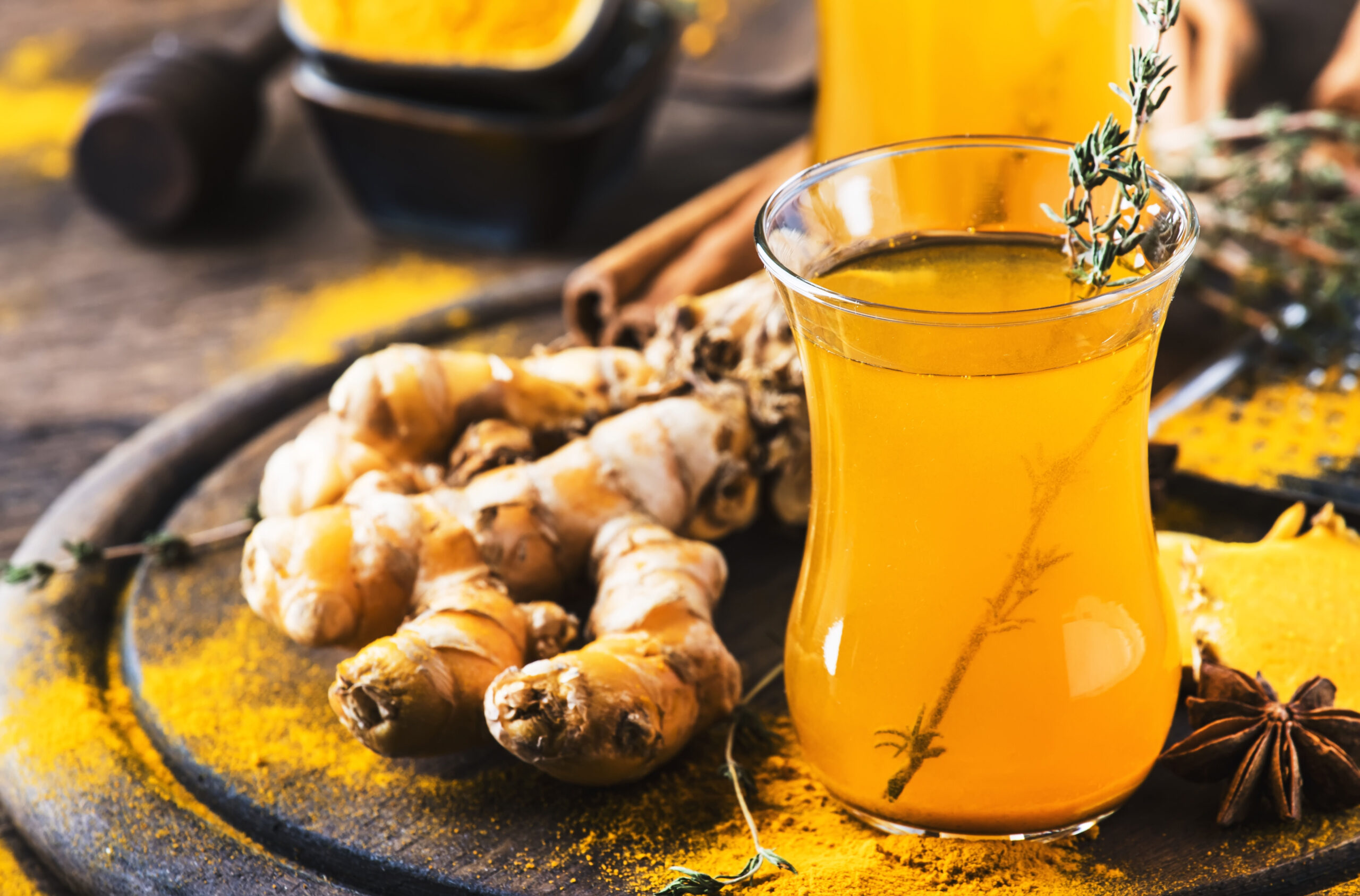 Healthy vegan turmeric golden tea with honey in glass cup on woo