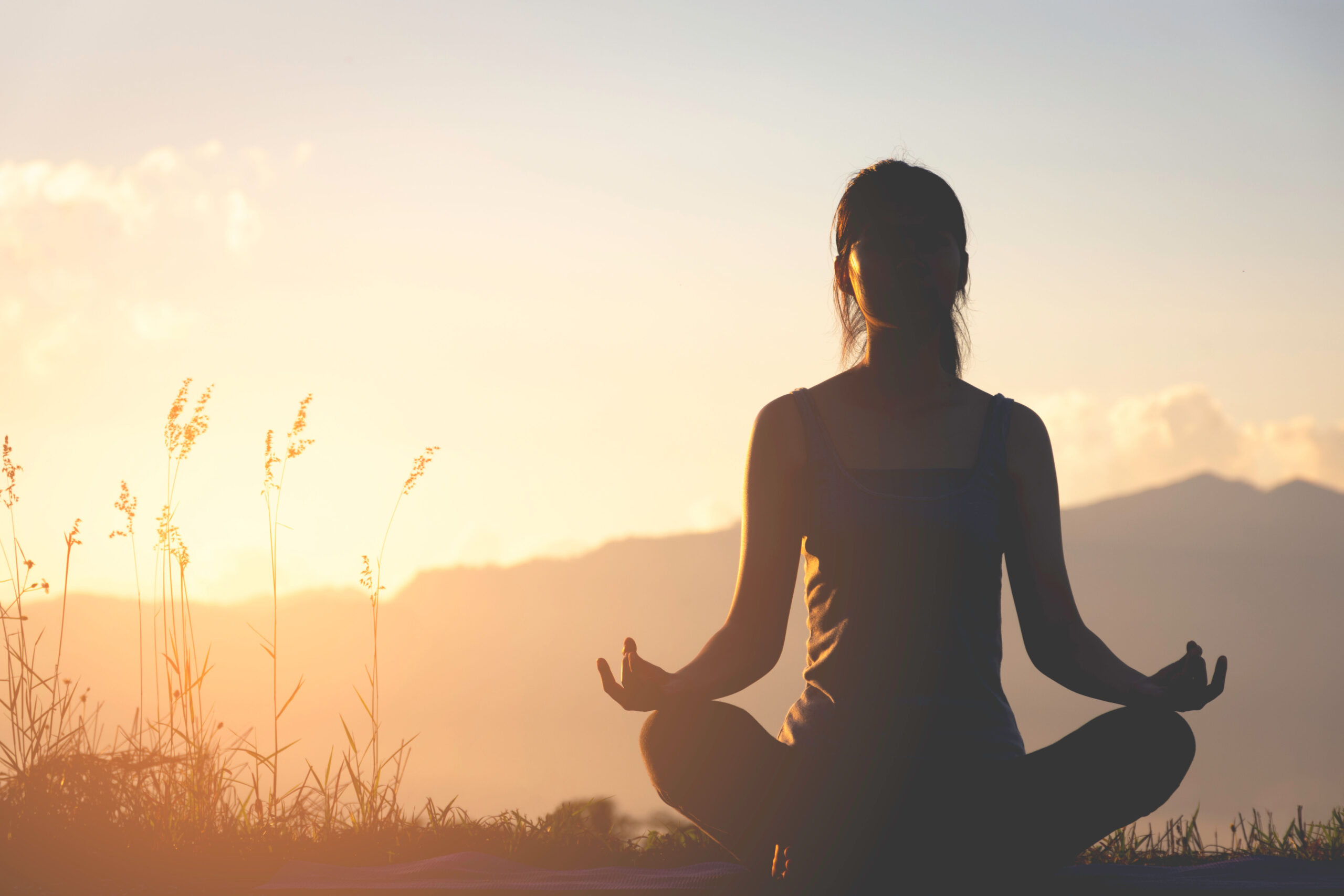 silhouette fitness girl practicing yoga on mountain
